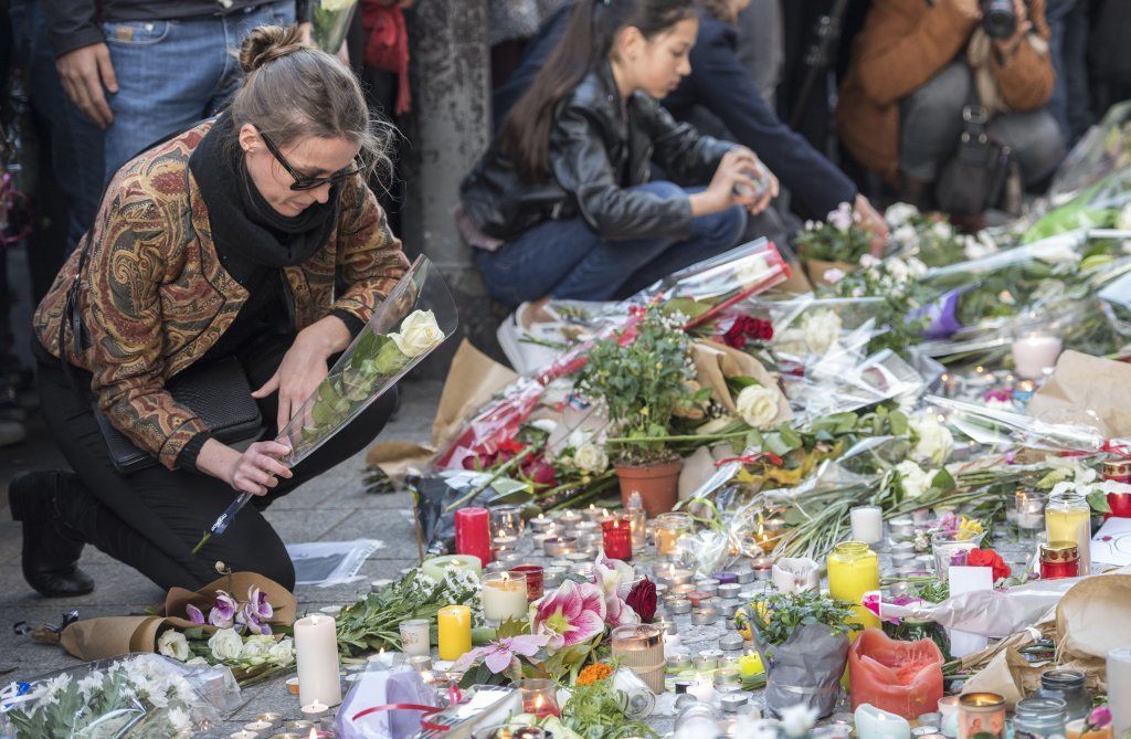 A Woman Places A Flower in Paris At The Bataclan.