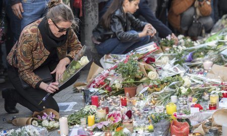 A Woman Places A Flower in Paris At The Bataclan.