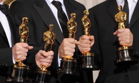 Hands holding Oscars